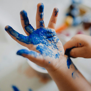 Photo of child's hand covered in paint